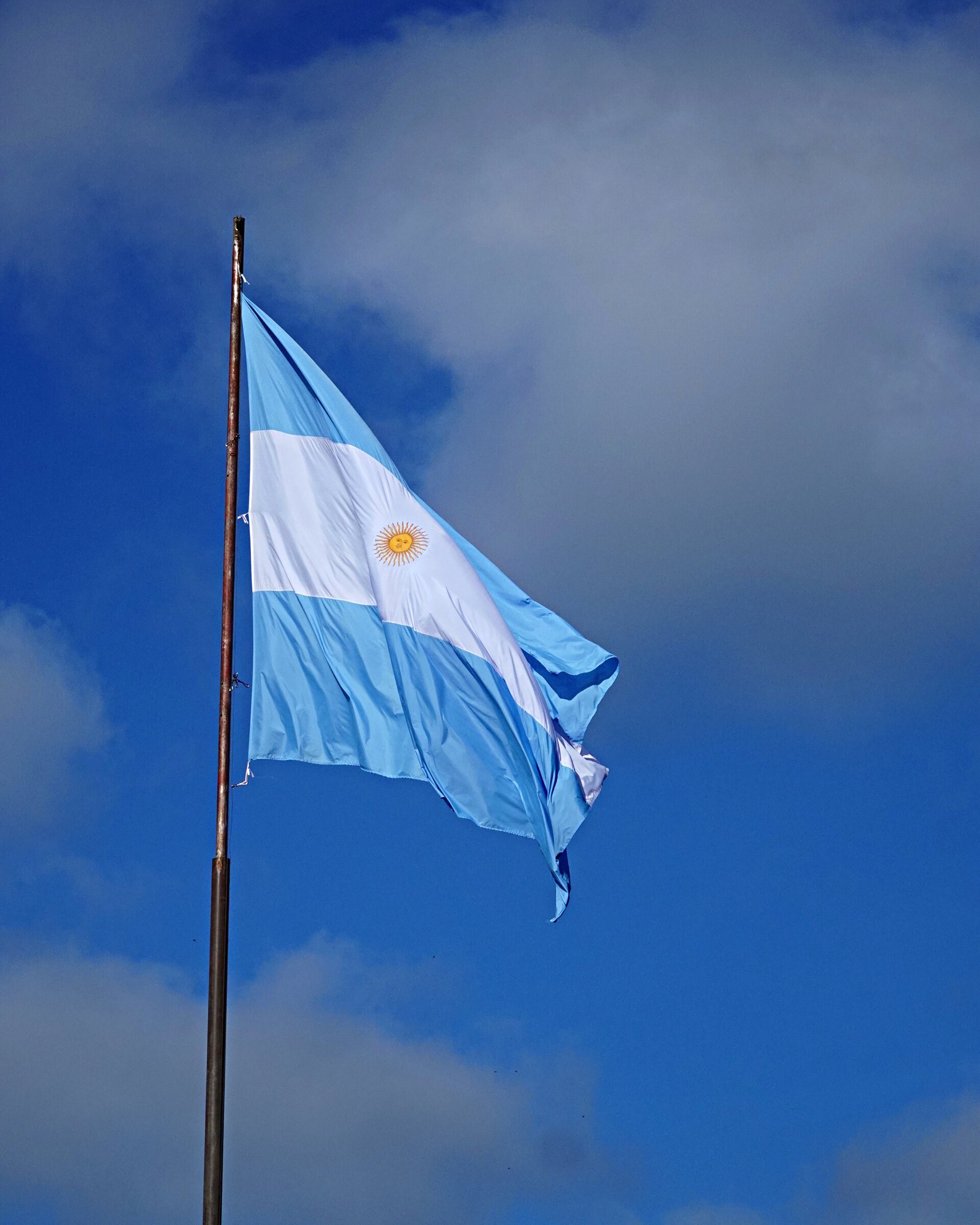 The Argentine flag flying against a deep blue sky