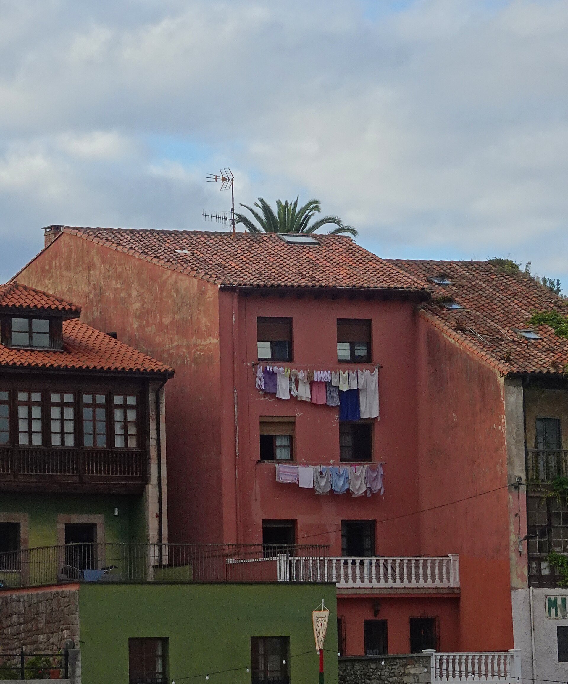 Washing hung across the face of a red house with tiled roofs