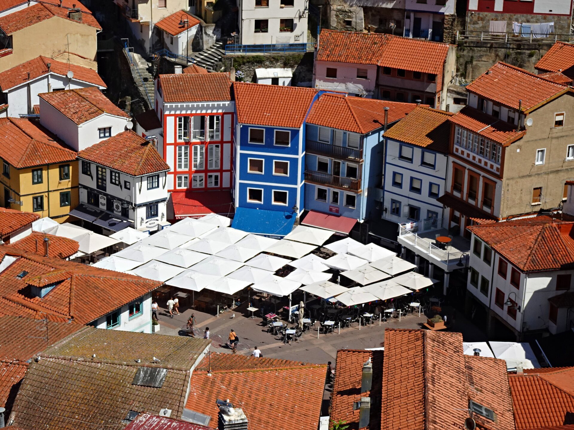 Coloured houses and café umbrellas packed into a steep fishing village