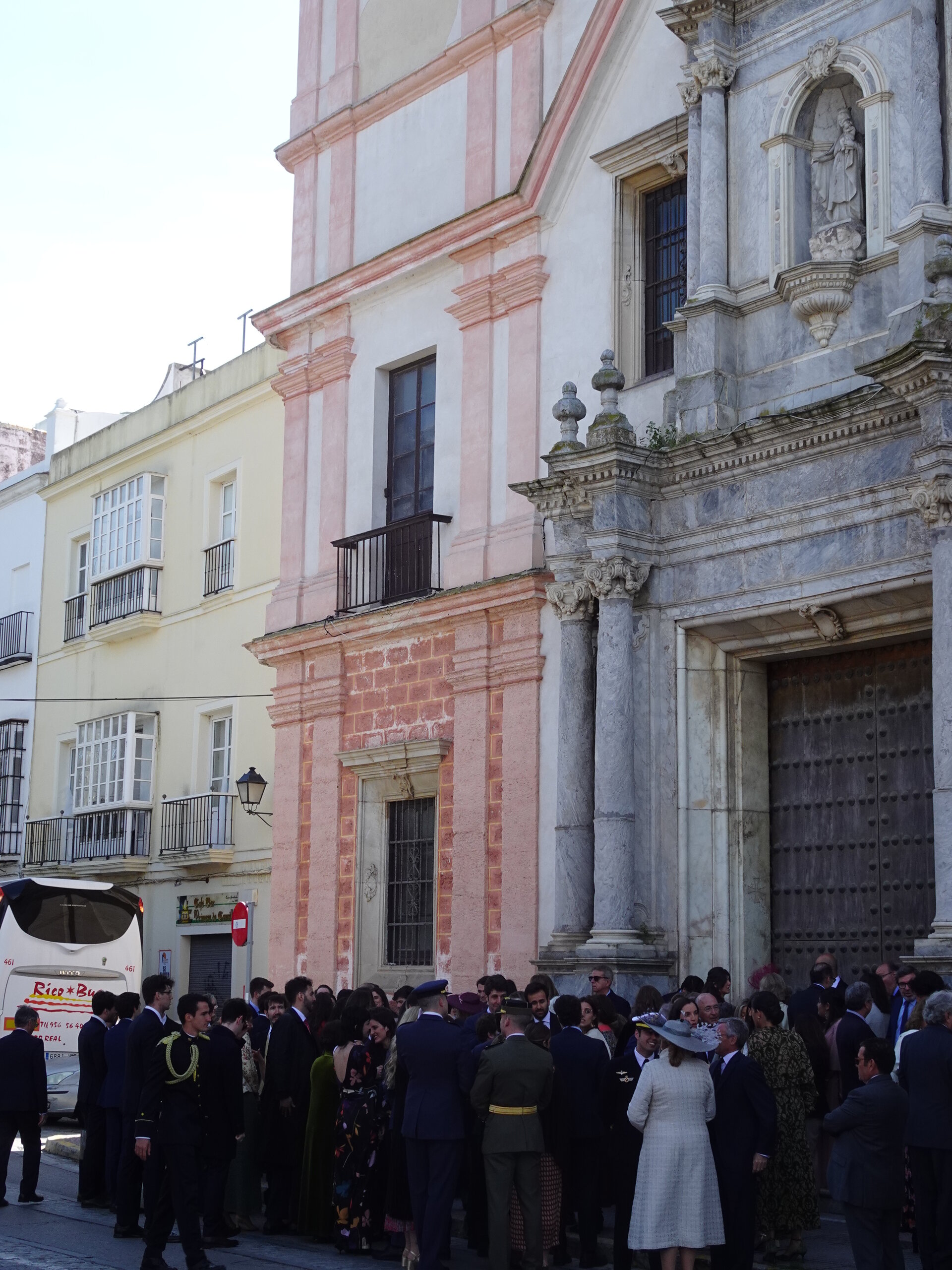 Crowd gathered outside a baroque church in formal dress
