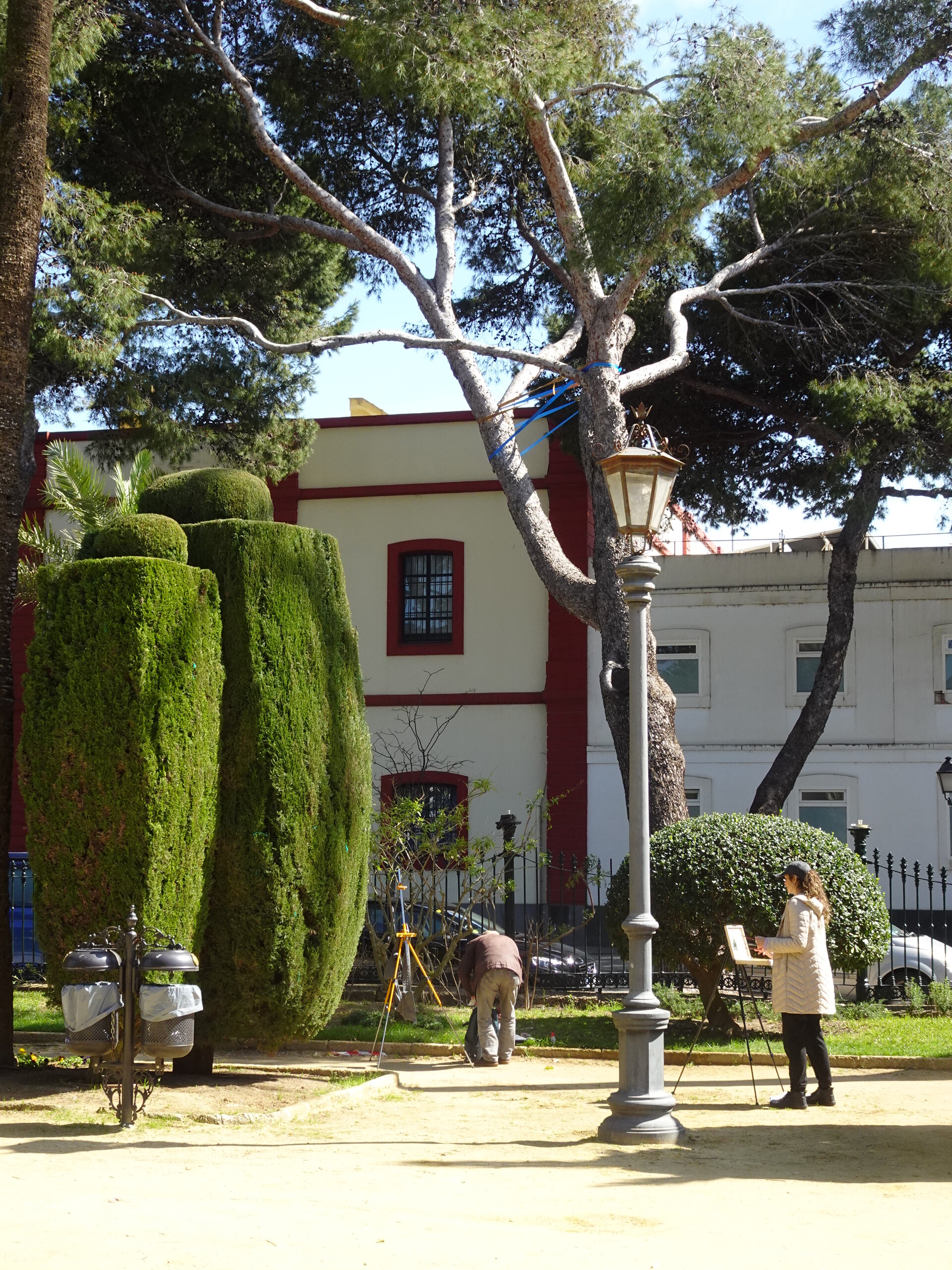Sculpted hedges and a street lamp in a manicured park