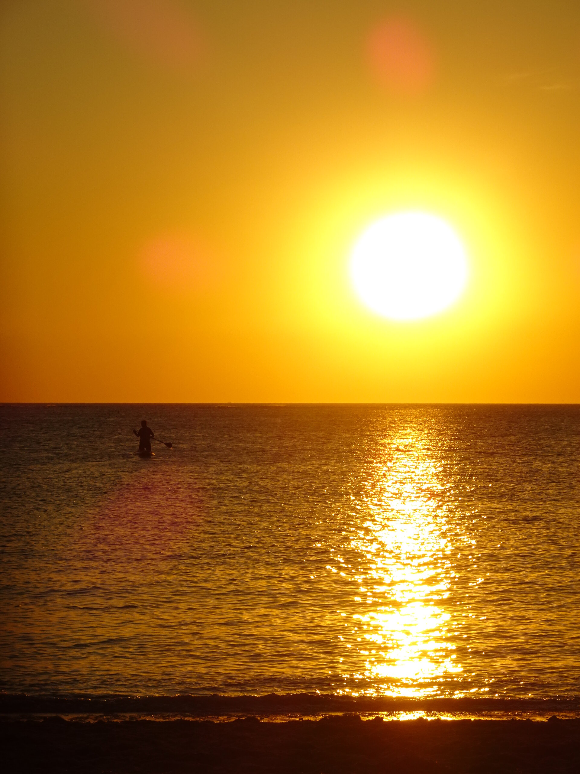 Golden sunset with a lone figure silhouetted in the sea