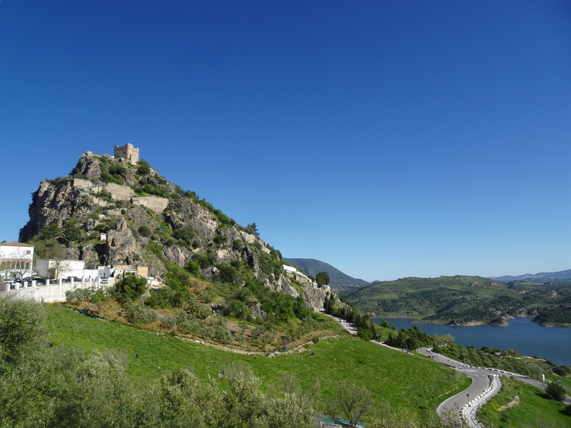 Castle ruins on a hilltop above a blue reservoir