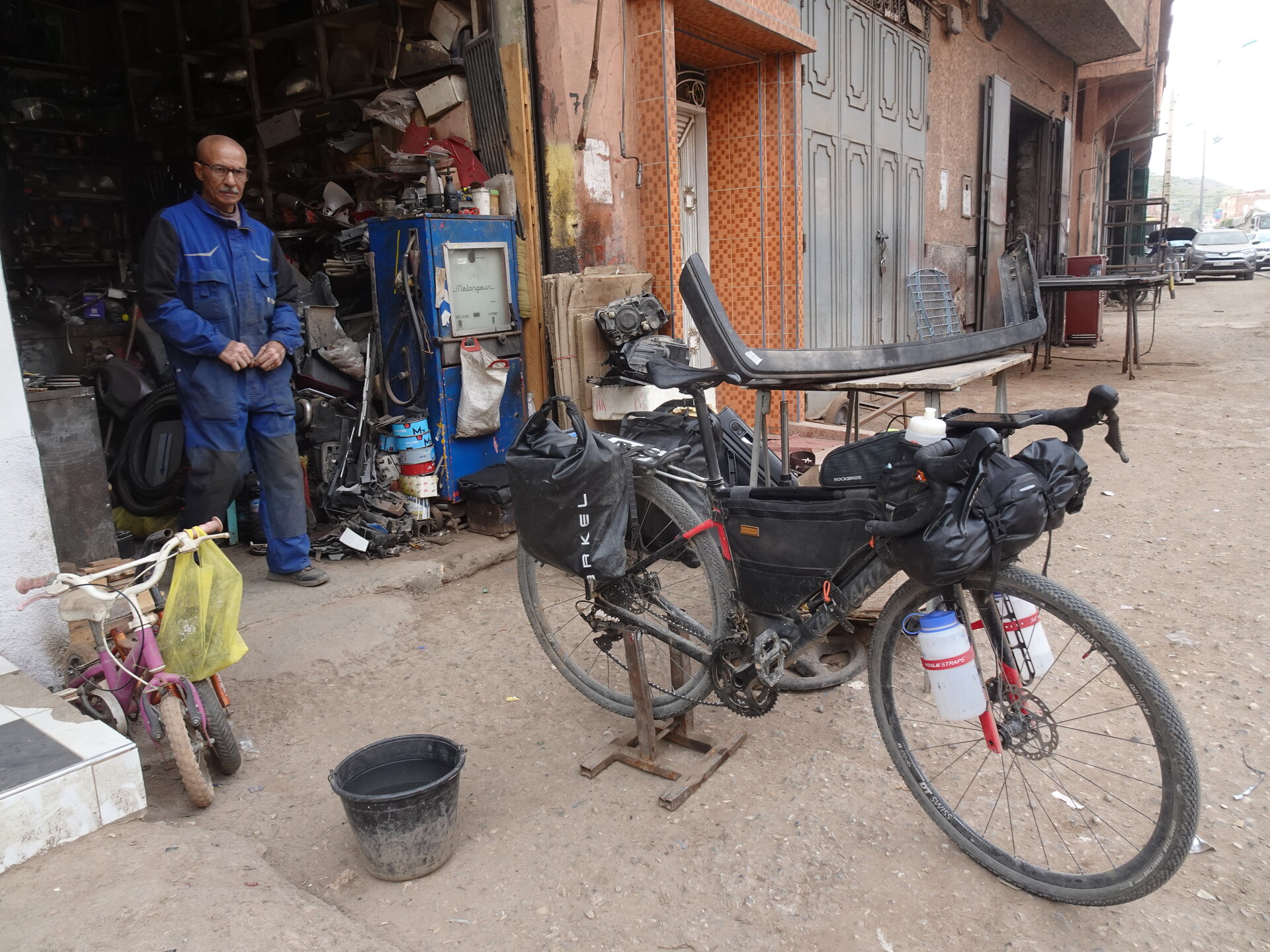 Loaded touring bike outside a mechanic's workshop