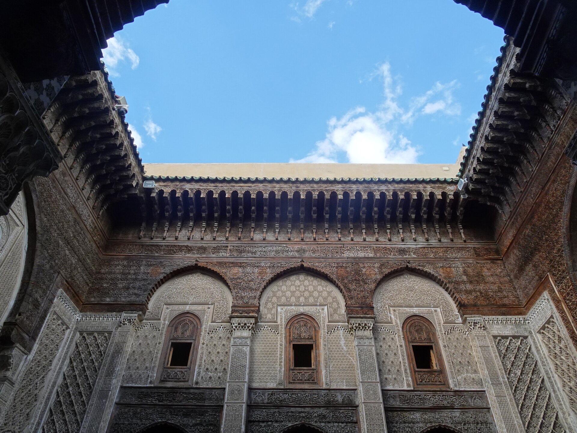 Intricate carved stucco and tilework courtyard of a Fes madrasa