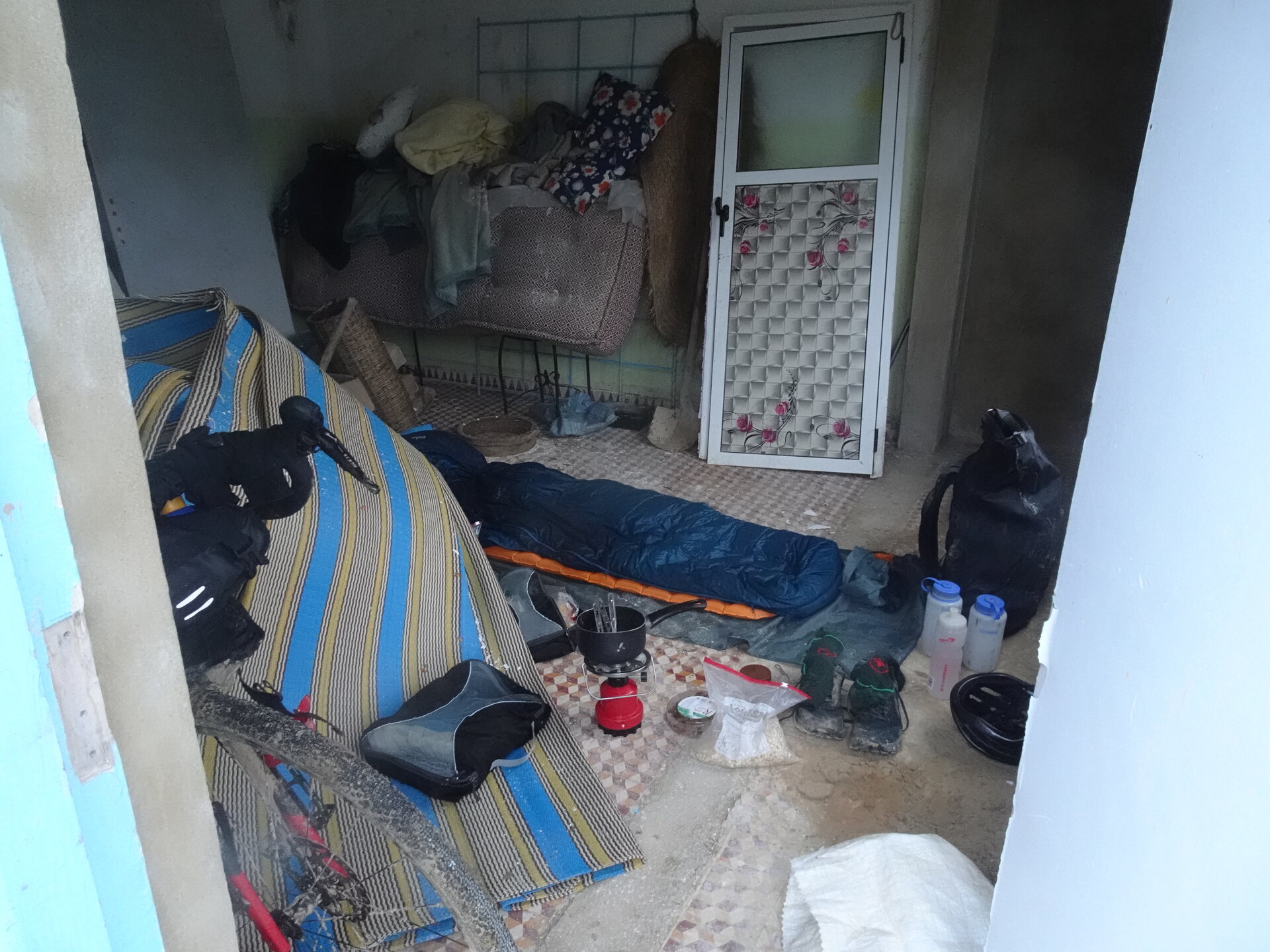 Sleeping bag and camping stove set up inside a small storage room