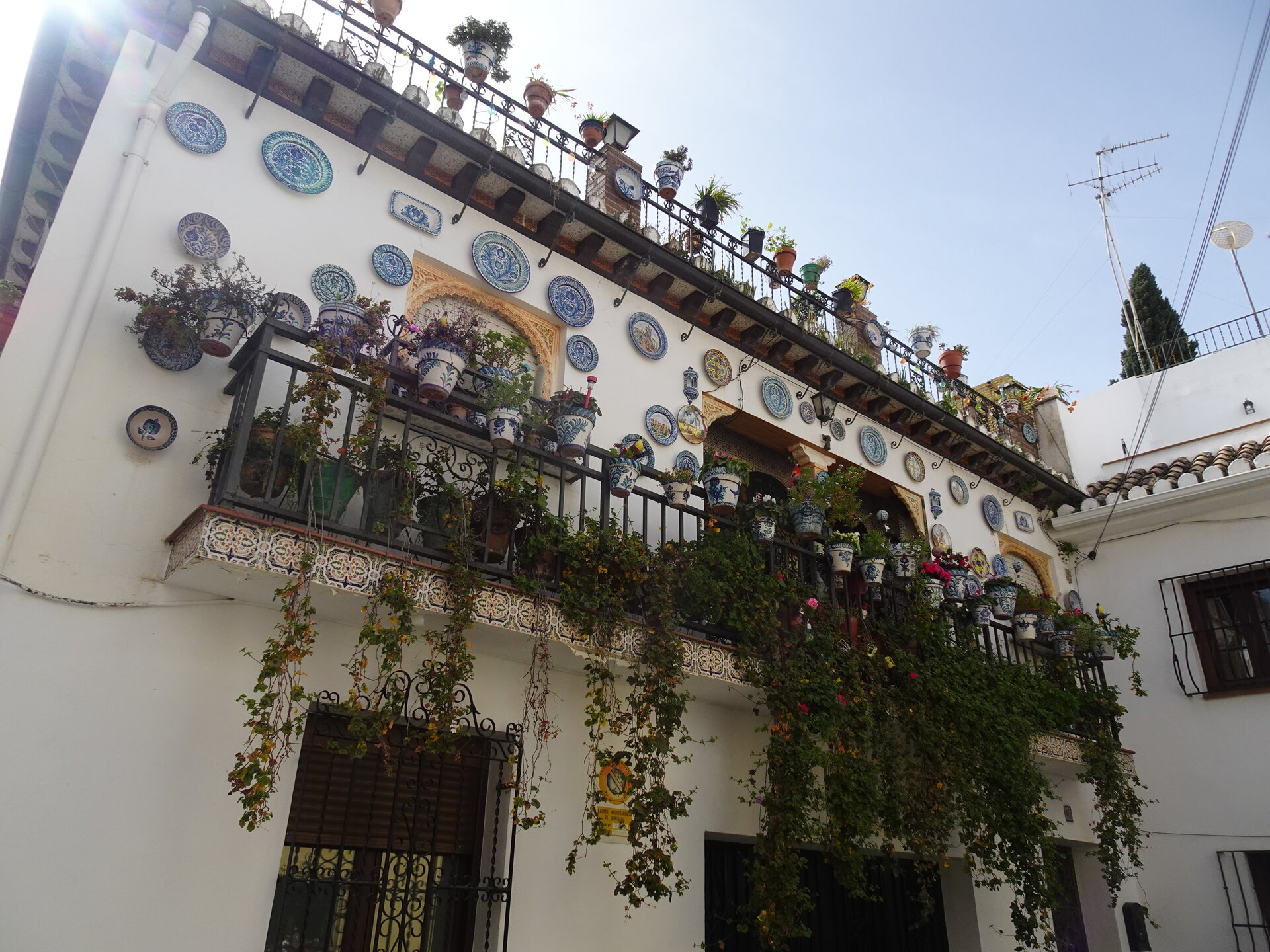 Balcony hung with painted ceramic plates and trailing plants