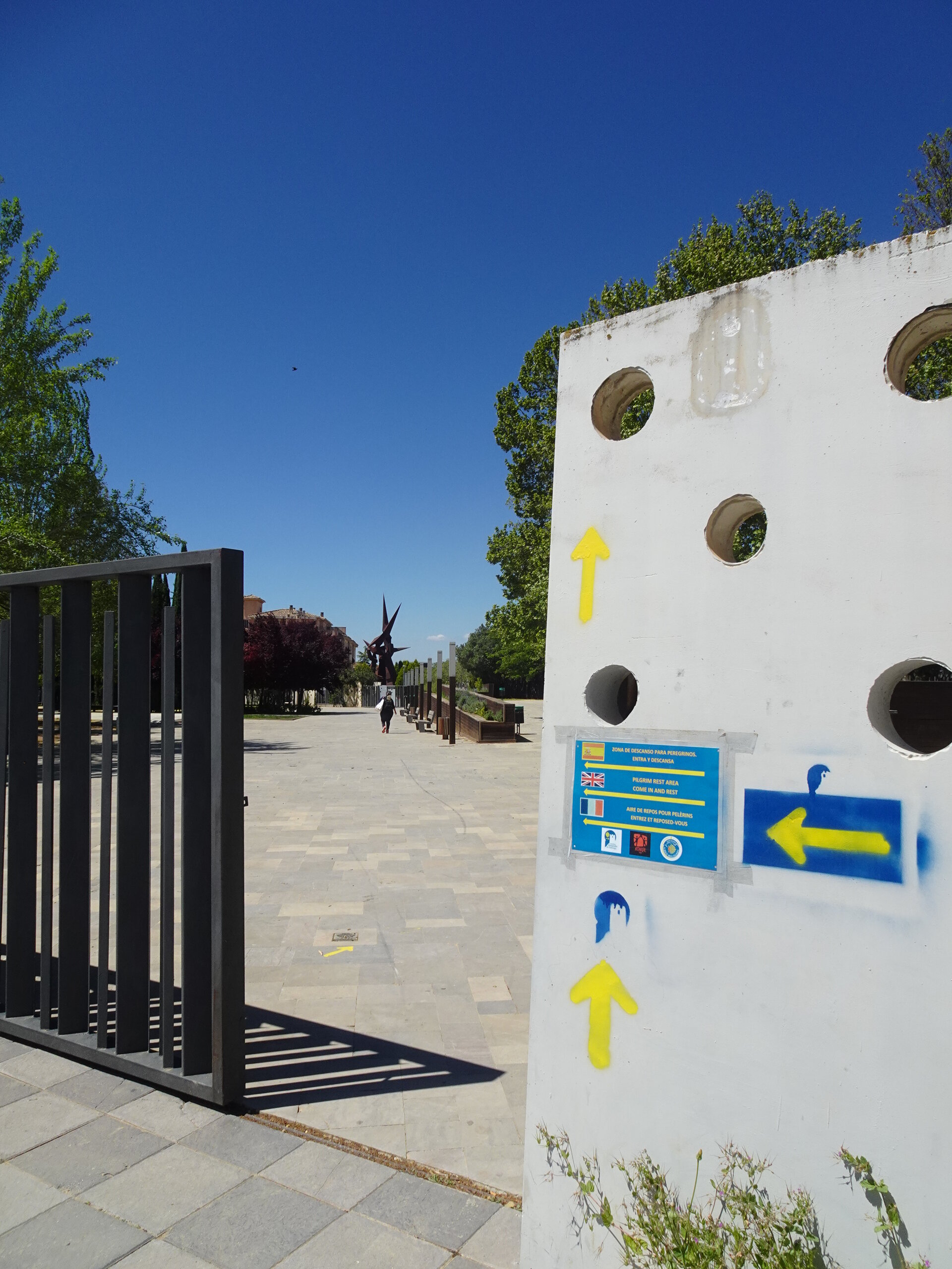 Camino way markers with yellow arrows on a whitewashed gate post