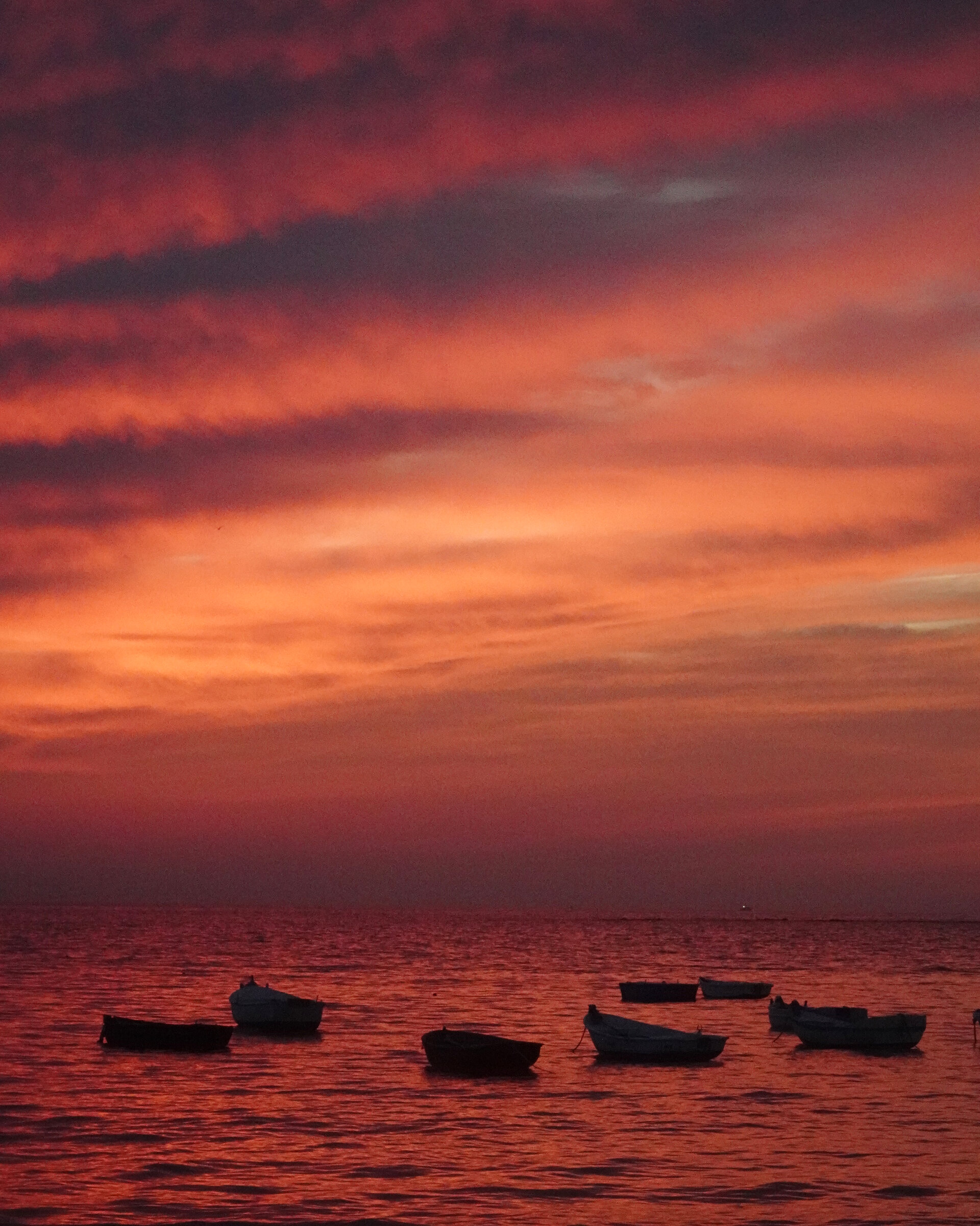 A fiery red sunset glowing over a calm sea