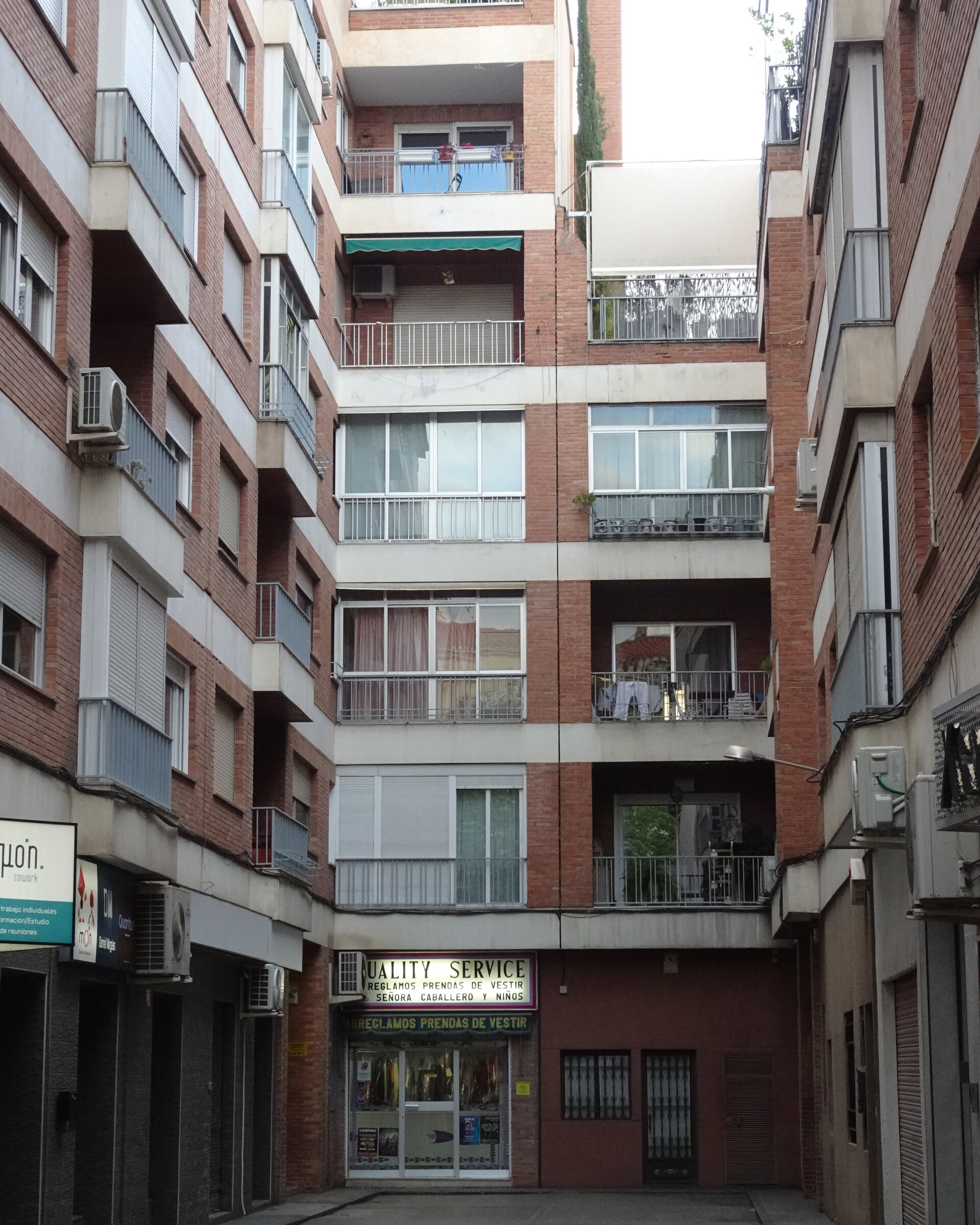 A tall apartment facade with rows of windows and shuttered balconies