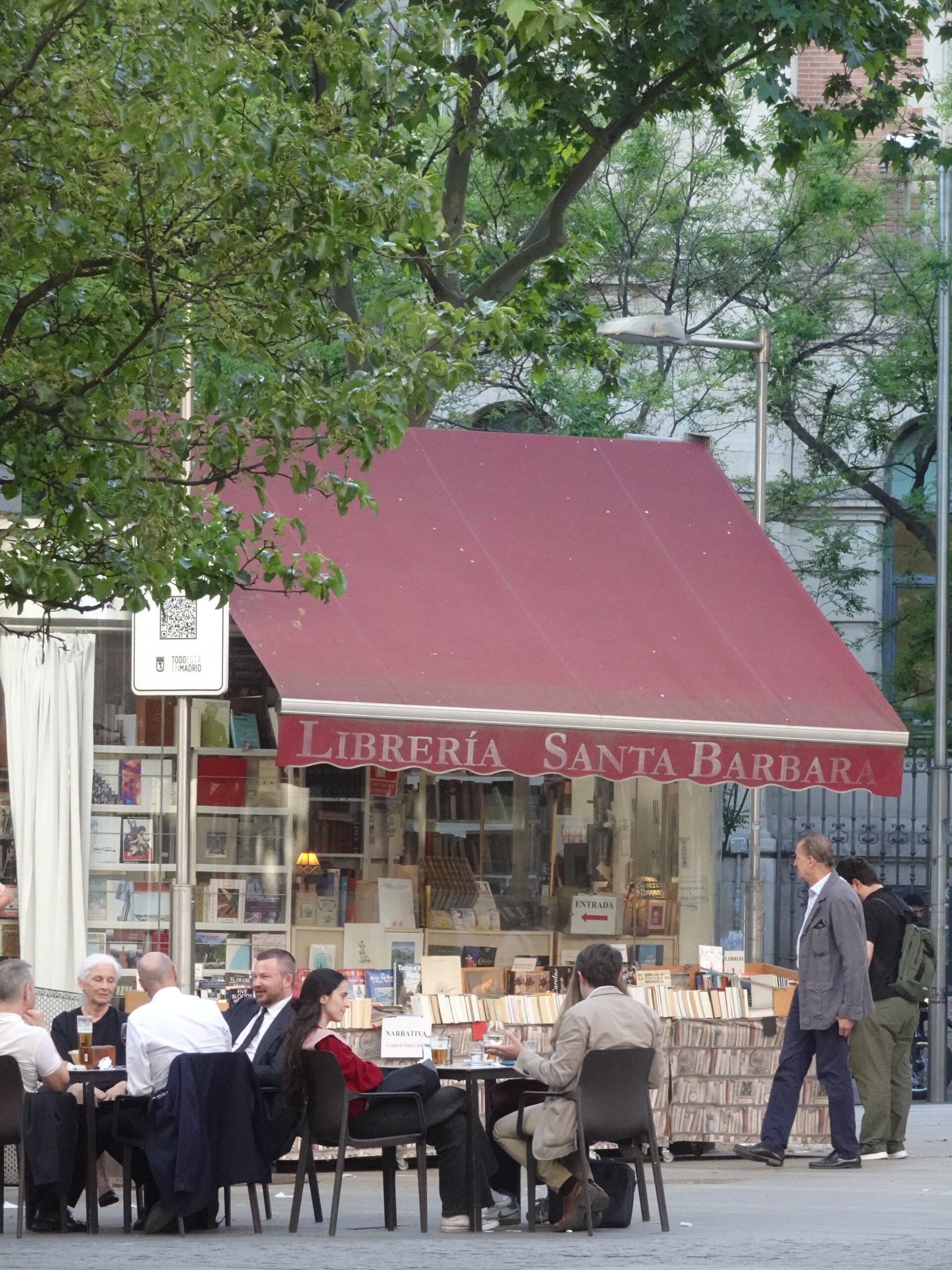 Outdoor cafe tables beside the Libreria Santa Barbara bookshop awning