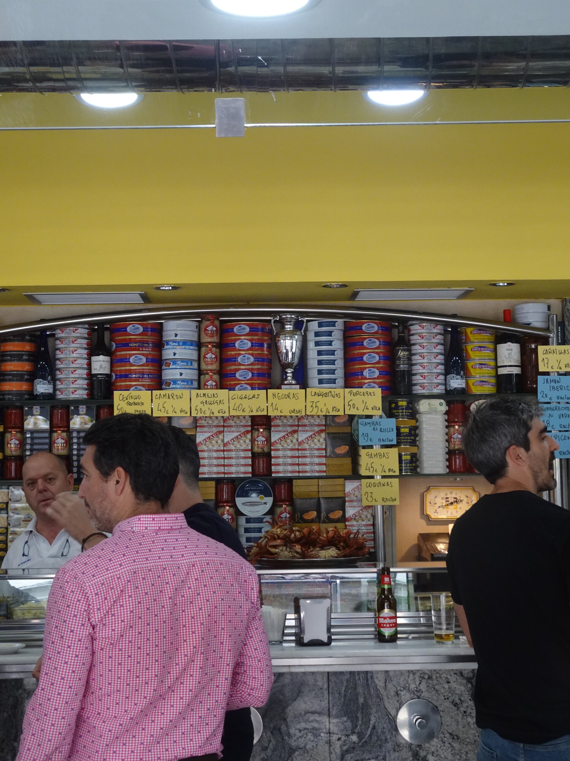 People at the counter of a tinned-seafood and beer bar