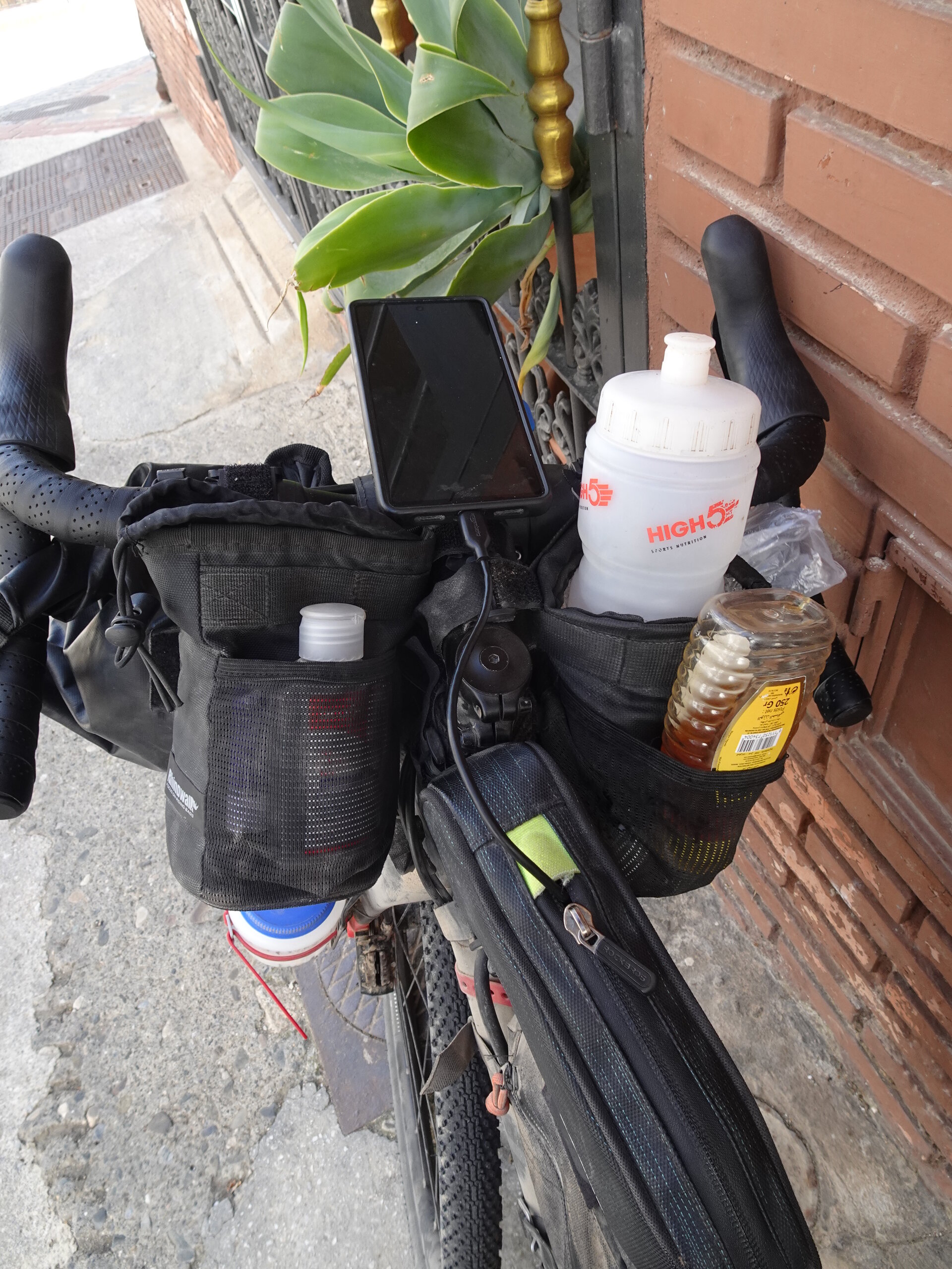 Bike handlebar bag loaded with bottles and phone mount
