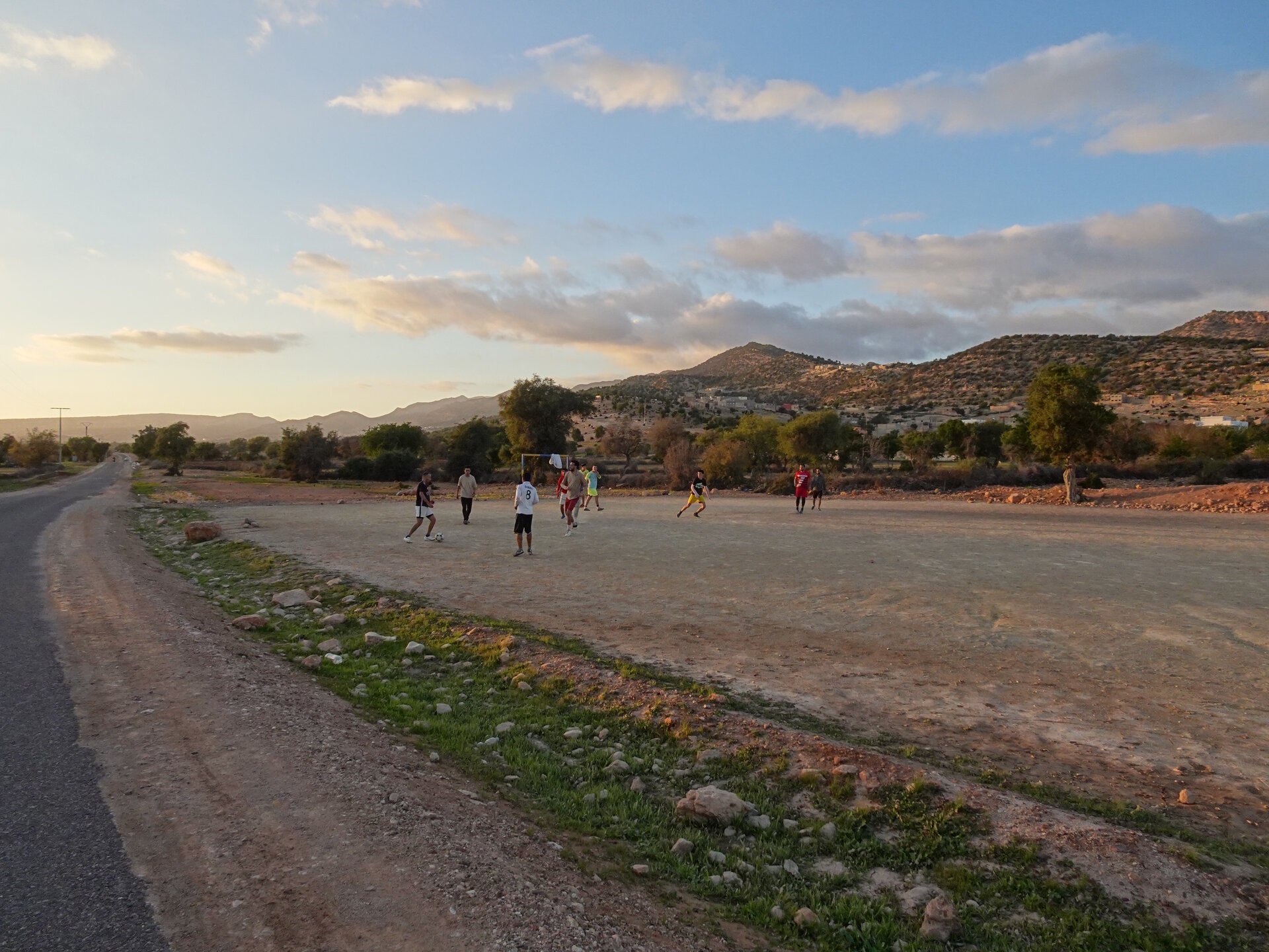 A group playing football at dusk